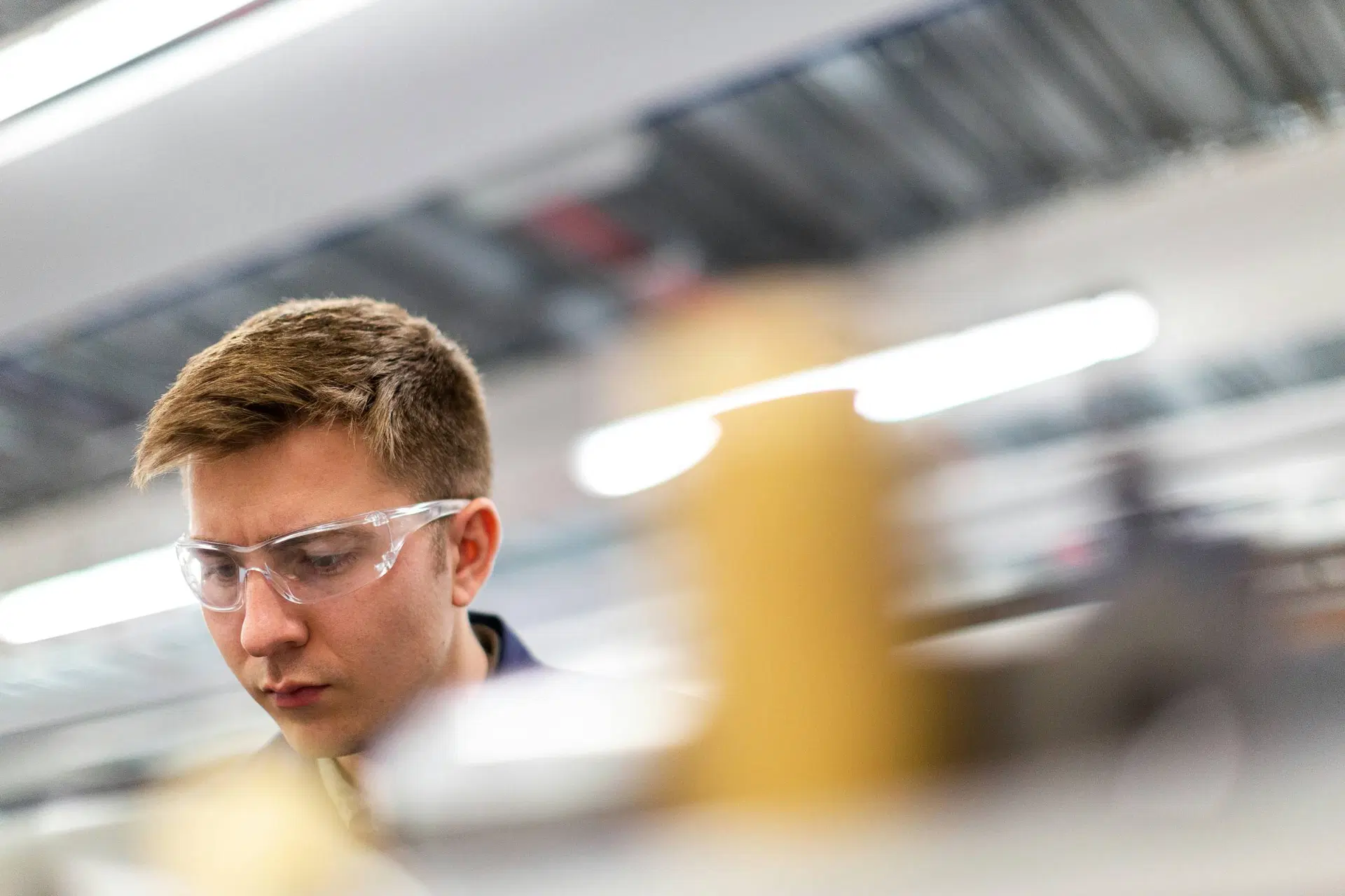 Mitarbeiter:in mit Schutzbrille in einer industriellen Umgebung